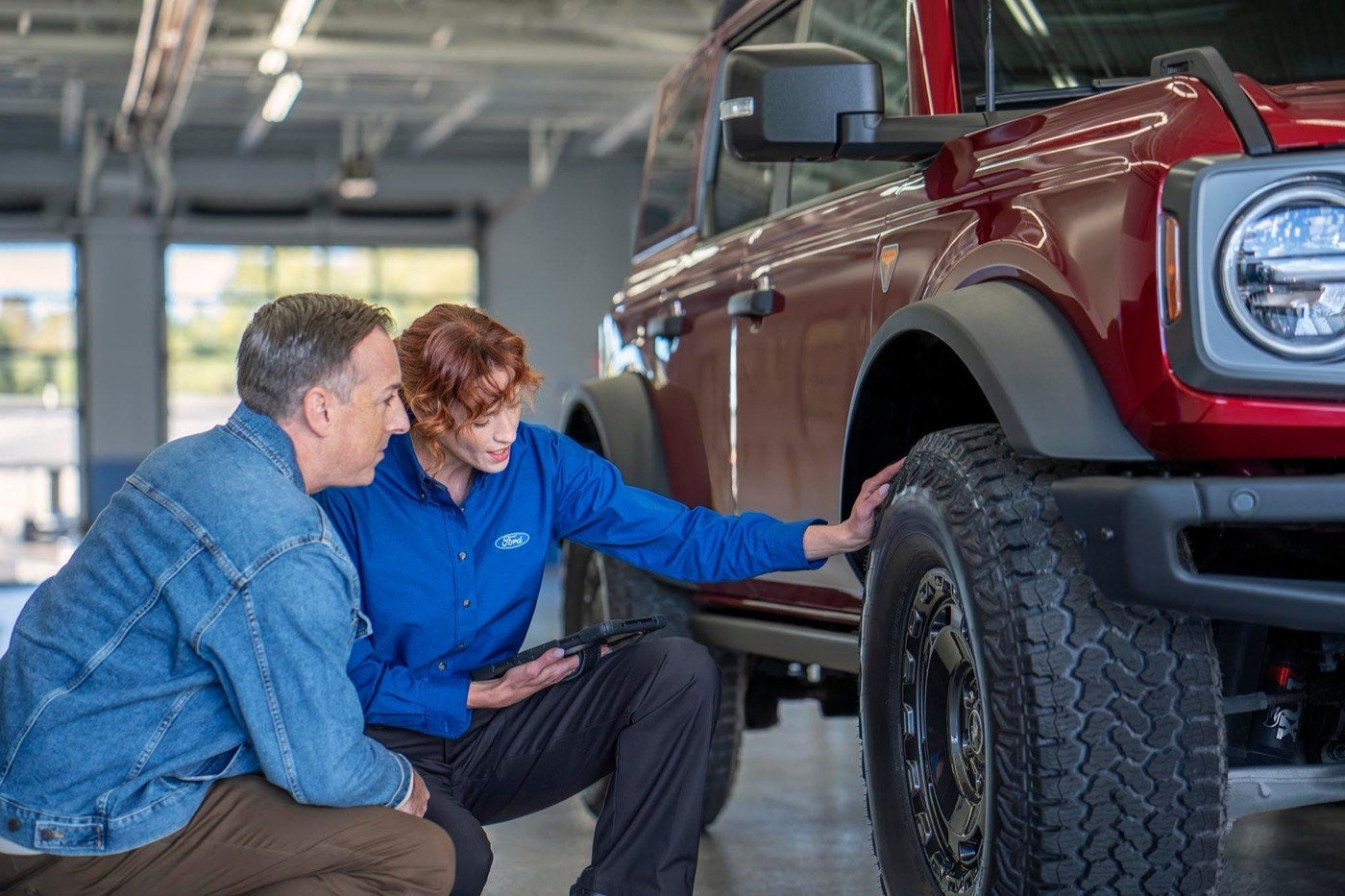 Ford Service representative and owner checking the wear on a tire