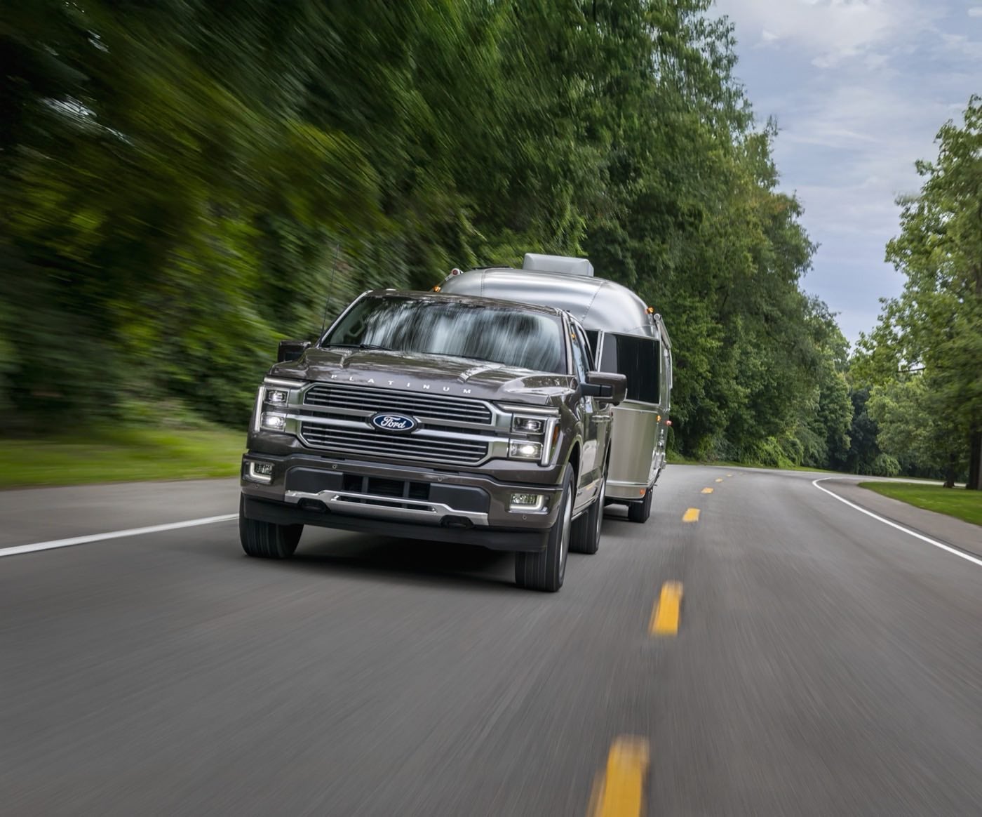 Ford F-150 Platinum in Marsh Gray pulling a camper