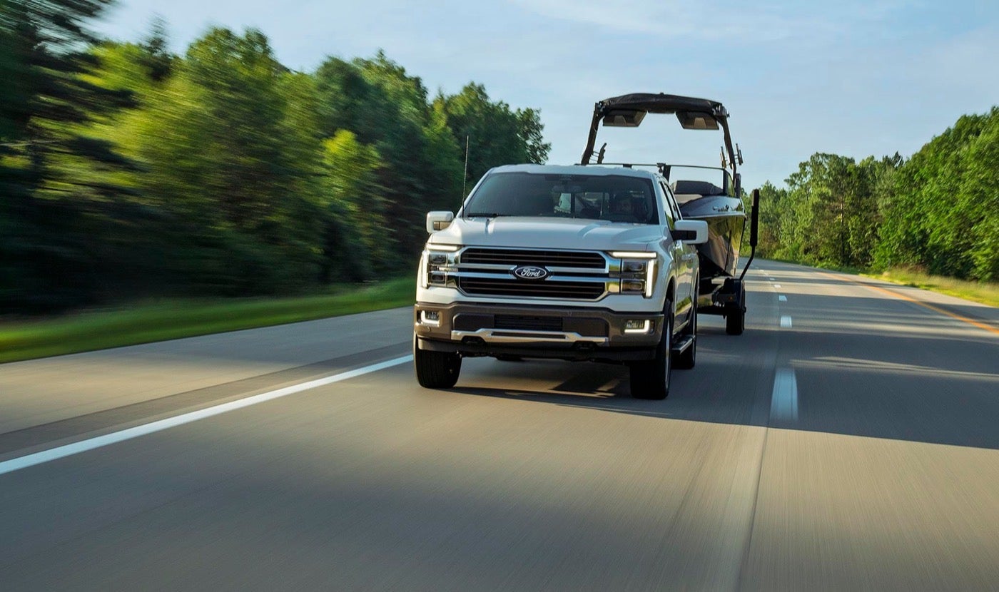 Ford F-150 Lariat pulling a boat on a highway