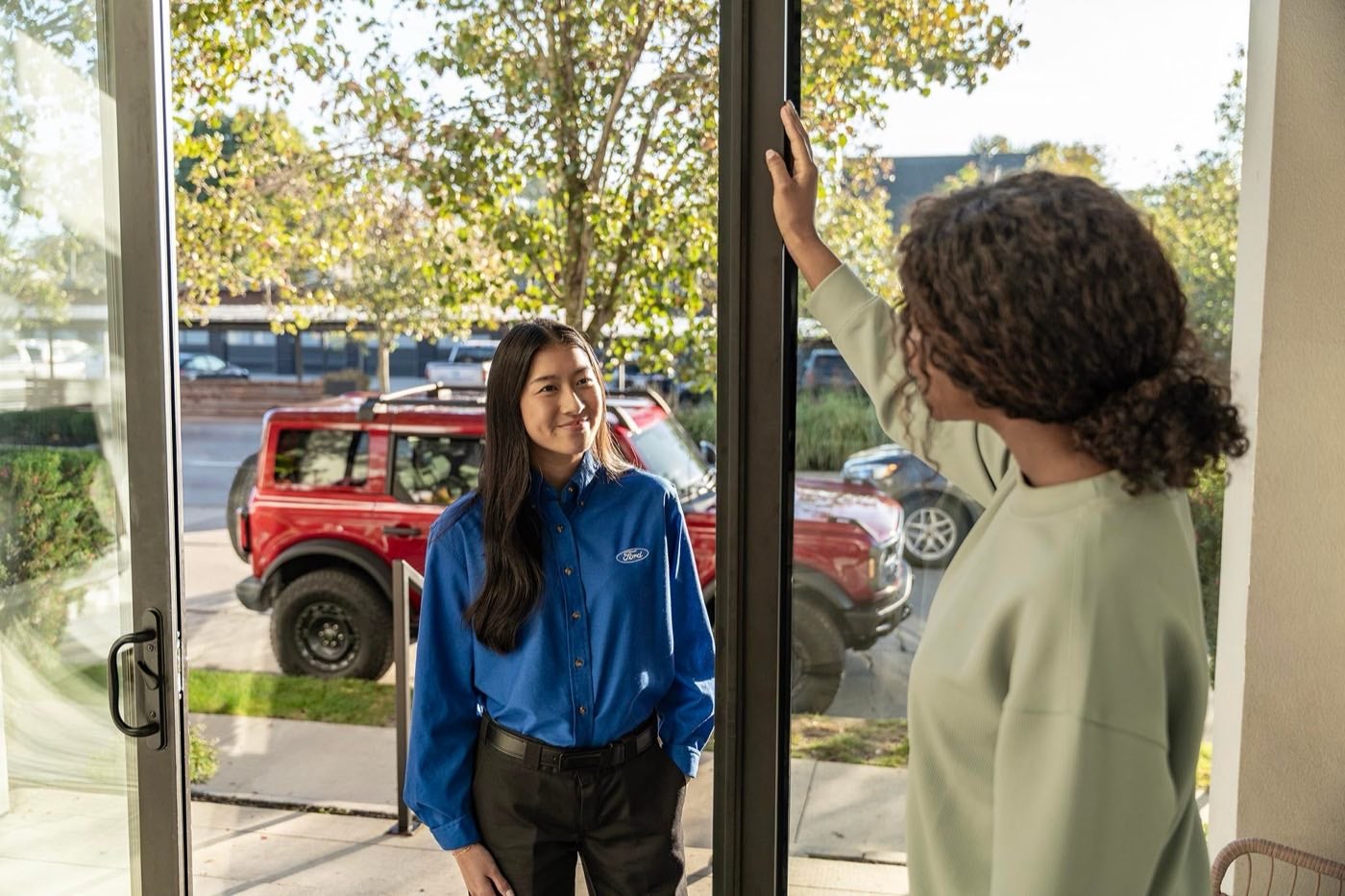 Ford Pickup and Delivery representative greeting an owner at home