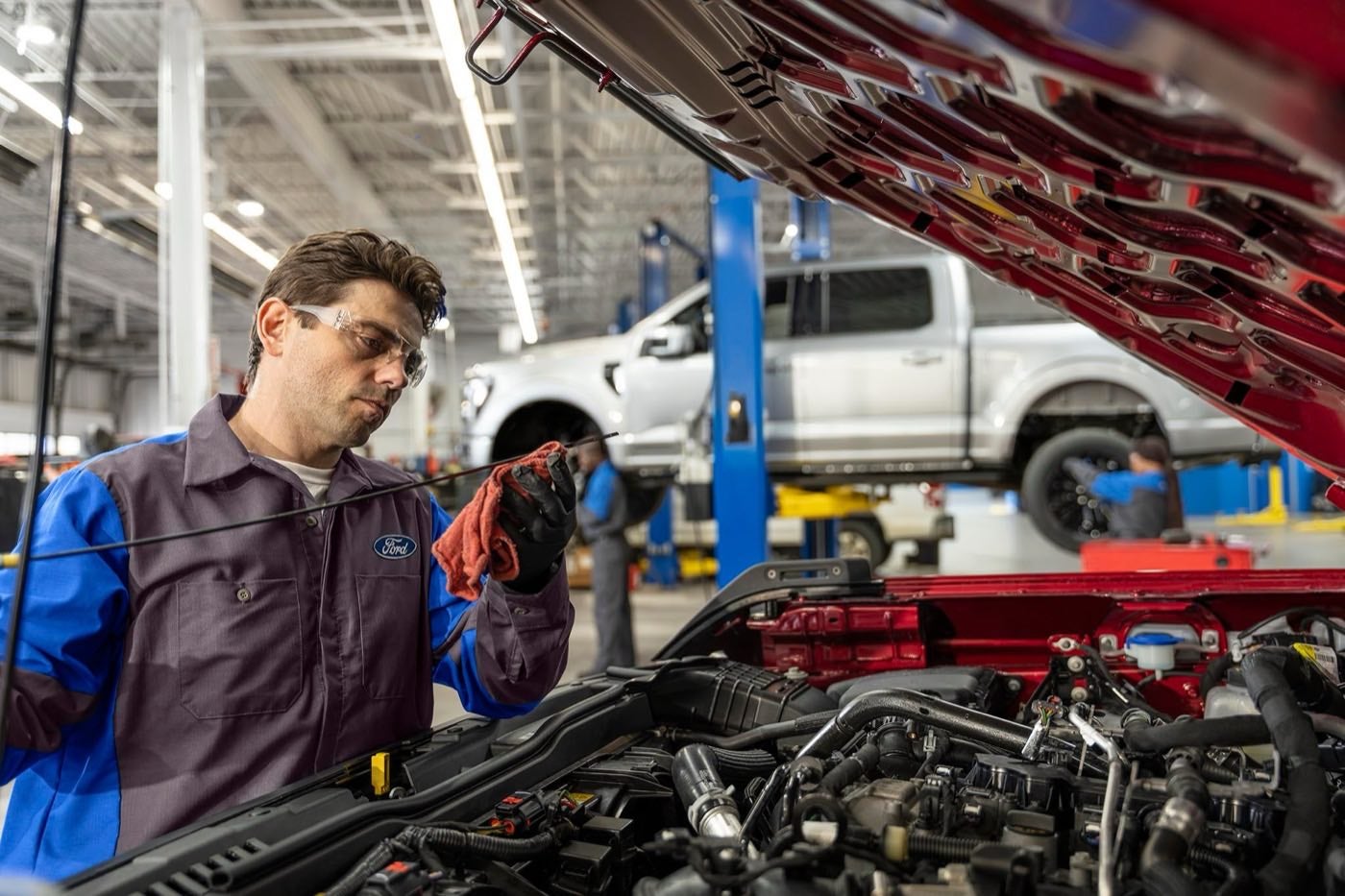 Ford Service technician checking the oil on a Ford vehicle